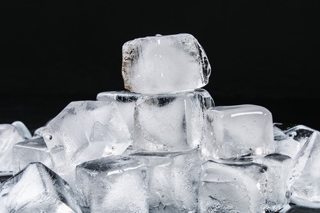 Cubes of ice from water with mint leaves on a black backgroundの写真素材