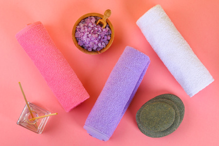 Spa on a pink pastel background. Towels, stones, aromamaslo, purple salt bath and pink flowersの写真素材