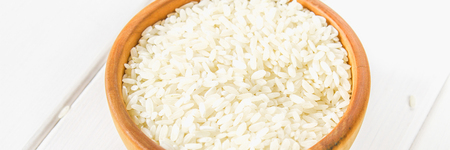 Grains of raw white rice on a white wooden table of boards. Ingredients for cookingの写真素材