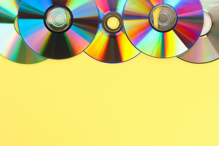 Piles of old and dirty CDs,DVD on pastel background. Used and dusty disk with copy space for add textの写真素材