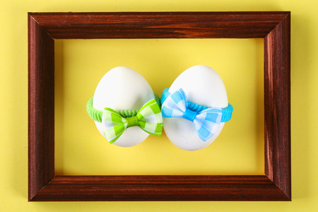 The concept for the international friendship day. Eggs in bows on a yellow pastel background