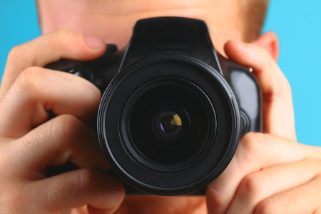 photographer with camera in hand looking through the camera lens