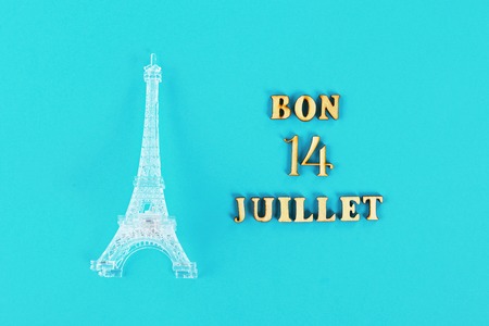 Text in French Good July 14. Miniature of the Eiffel Tower on a blue background. The concept of the holiday The day of the capture of the Bastilleの写真素材