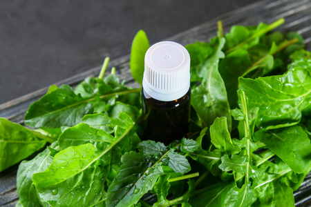 Cosmetic oil from arugula on an old wooden tableの写真素材