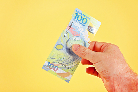 New Russian money 100 rubles. Plastic commemorative banknotes with images of maps of the world and...