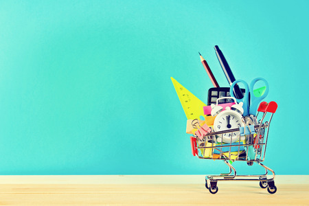 Shopping cart with stationery objects. Office and school supplies
