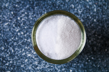 Different types of salt in glass bowls on a dark gray tableの写真素材