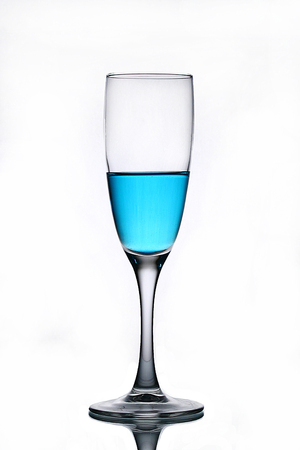 Blue liquid in a champagne glass on a white backgroundの写真素材