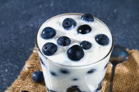 Yogurt with blue blackthorn berries in a glass. Berry dessertの写真素材