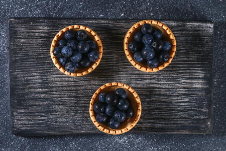 Blue blackthorn berries in sand tartlets on a tableの写真素材