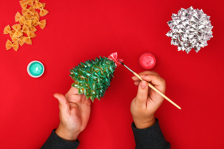 How to make a Christmas tree from raw pasta bows. The process of making Christmas trees from pasta, cardboard plates, hot glue and paint or spray. Guide, step by step on the photo. Handmade, DIYの写真素材
