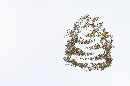 Christmas layout. Golden confetti in the form of stars folded in the shape of Christmas tree a white...