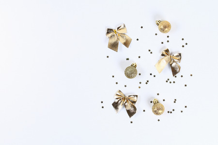 Christmas layout. Golden confetti in the form of stars, toy ball and bows on a white background. New Year 2019, christmas, winter concept. Copy space, tov view, flat lay compositionの写真素材