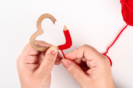 Red handmade diy hearts made of cardboard, yarn on a white background. Gift ideas for Valentines Day, day love, concept of February 14. Step by step. process crafts. Valentine cardの写真素材