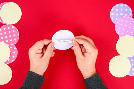 Diy cookie with predictions on a red background. Gift ideas, decor for the Chinese new year. Handmade. Fortune cookies from a multi-colored cardboard. Step by step. The process of crafts. Top view.の写真素材