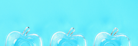 Banner. Glass cups for honey in the form of apples on a pastel of blue background. Rosh Hashanahの写真素材
