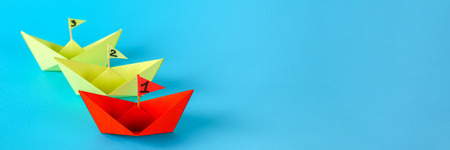 Three paper ships compete who swims faster. Red wins the shipの写真素材