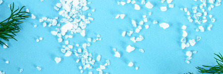 Crystals of large sea salt and dill on a blue table. Background for advertising salt. Table salty. Salted foodの写真素材