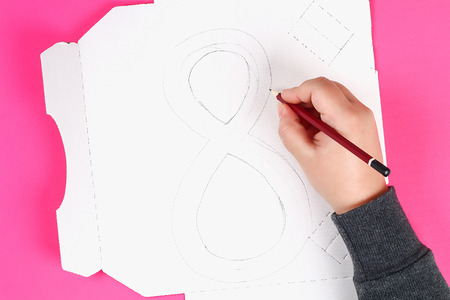 Diy eight made cardboard decorated artificial flower made blue tissue paper napkin pink background. Gift idea, decor International Womens Day, March 8. Step by step. Top view. Process childrens craft.の写真素材