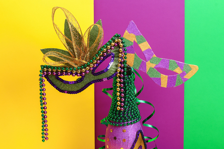 Diy Mardi Gras bottle purple self adhesive paper, green bead, carnival mask, sequins yellow background. Gift idea, decor Mardi Gras, Fat, Shrove Tuesday. Step by step. Top view. Process children craftの写真素材