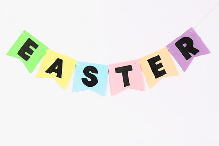 Diy Easter garland bunnies, flags with letters EASTER made of multicolor paper on a white wall background. Gift idea, decor Spring, Easter. kid children craft. Handmade.の写真素材