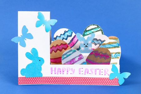 Diy Easter eggs made of cardboard and potato stamp, Easter greeting card on blue background. Gift idea, decor Spring, Easter. Step by step. Top view. Process kid children craft.の写真素材