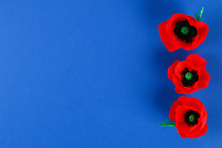 Diy paper red poppy Anzac Day, Remembrance, Remember, Memorial day made of crepe paper on blue background. Symbol war. Gift idea, decor. Step by step. Top view. Process kid children craft. Workshopの写真素材