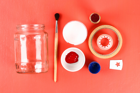 1 Diy vase 4th of July glass jar, paint, glitter, tape color American flag, red blue white. Gift idea, decor July 4 USA Independence Day. Step by step. Top view. Process kid children craft. Workshop.の写真素材