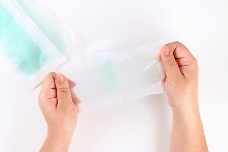 The girl uses strips for depilation in her hands on a white background. Top view.の写真素材