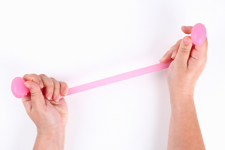 Girl pulls gymnastic expander elastic for hands on a white background. Top view.の写真素材