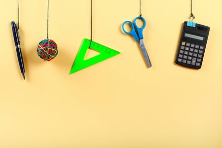 School supplies hang on the rope. School supplies on yellow background. Back to school concept