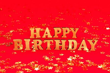 Text Happy birthday laid out of gold letters on a beautiful background. Golden stars confetti.の写真素材