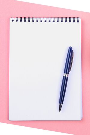 Empty notebook with blue pen on a pink pastel background. mock-up, frame, templateの写真素材
