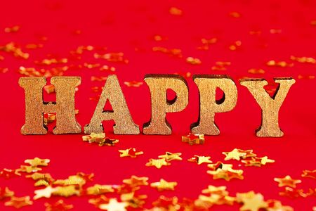 Text Happy laid out of gold letters on a beautiful background. Golden stars confetti.の写真素材