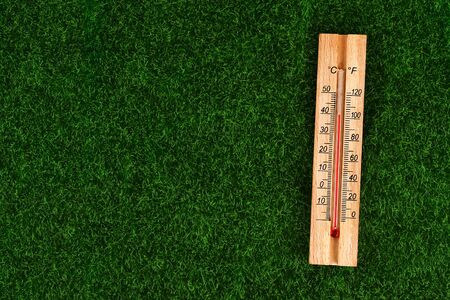 Thermometer displaying high 40 degree hot temperatures in sun summer day. temperature 40. Summer temperature. Thermometer on the grass. Top view. Copy space.の写真素材