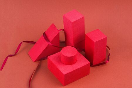Red geometric shapes with a ribbon on a brown background. Template composition for advertising, products.の写真素材