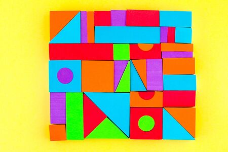 Kids designer of multi-colored volumetric 3d geometric shapes on a yellow background. Logical...