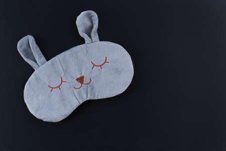 Gray sleep mask on black background composition, mouse mask with ears, flat lay, top viewの写真素材