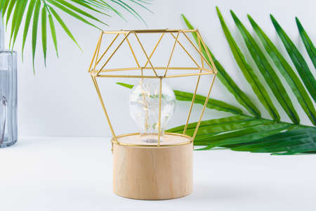 Modern geometric lamp with copper wire lampshade. Metal frame of the lamp. Decor for a modern interior.の写真素材