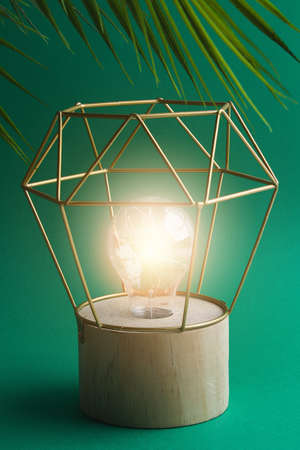 Modern geometric lamp with copper wire lampshade. Metal frame of the lamp. Decor for a modern interior.の写真素材