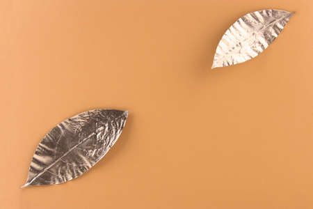 Leaves painted in gold on an orange background. Golden autumn concept.の写真素材