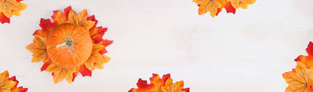 Autumn leaves and pumpkin over wooden background with copy space. Banner.の写真素材