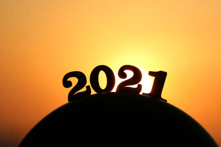 New Year 2021. The word 2021 behind the mountain at golden sunset and beautiful sky. Concept for...