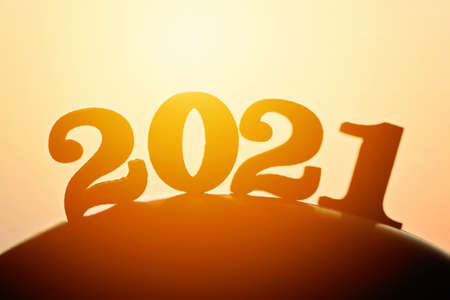 New Year 2021. The word 2021 behind the mountain at golden sunset and beautiful sky. Concept for vision year 2021の写真素材