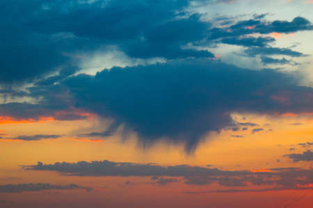 Dawn sky. Rain is gathering from the cloud. Red sky.の写真素材