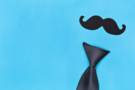 Fathers day card background on blue background. Composition of a tie, bow tie, mustache. Fathers day holiday concept.の写真素材