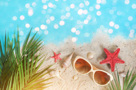 Tropical summer. Seashells, starfish on the sand by the sea. Tropical leaves. Summer time. Vacation,...