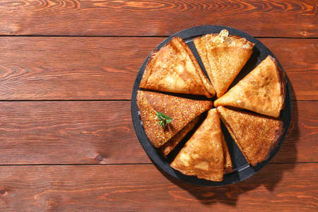 Thin pancakes from Russian cuisine. Russian blini, crepes on a wooden background. Shrovetide...