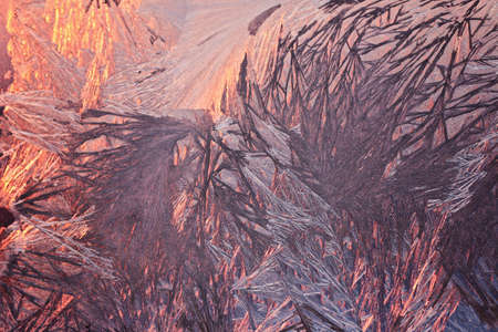 Winter snowy frosty patterns on the glass window. Winter magic. Frosty wonders. Abstract patterns.
