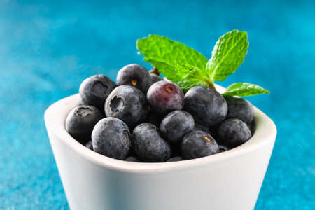 Blueberries, bog whortleberry, great bilberry on a blue background.の写真素材